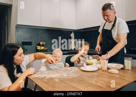 Gemeinsame Aktivitäten für Familienbacken in einem hellen und modernen Küchenbereich. Glückliche Familie genießt Momente des Kochens zu Hause. Stockfoto