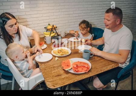 Eine Familie genießt das gemeinsame Frühstück in der komfortablen Umgebung ihres eigenen Zuhauses. Eine glückliche Familie genießt die Momente des gemeinsamen Essens Stockfoto
