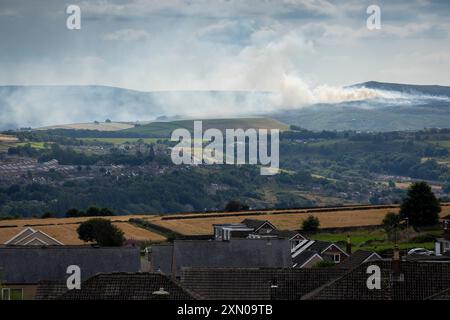 Huddersfield, West Yorkshire, Großbritannien, 30. Juli 2024 Eine Rauchwolke zieht durch die Landschaft von Pennine in der Nähe von Huddersfield, West Yorkshire, Großbritannien, als an einem der heißesten Tage des Jahres im Vereinigten Königreich ein Moorfeuer auf dem Marsden Moor brennt. Quelle: Windmill Images/Alamy Live News Stockfoto