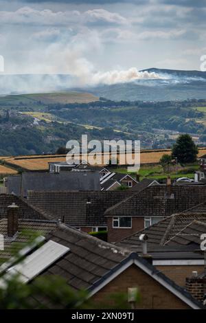 Huddersfield, West Yorkshire, Großbritannien, 30. Juli 2024 Eine Rauchwolke zieht durch die Landschaft von Pennine in der Nähe von Huddersfield, West Yorkshire, Großbritannien, als an einem der heißesten Tage des Jahres im Vereinigten Königreich ein Moorfeuer auf dem Marsden Moor brennt. Quelle: Windmill Images/Alamy Live News Stockfoto