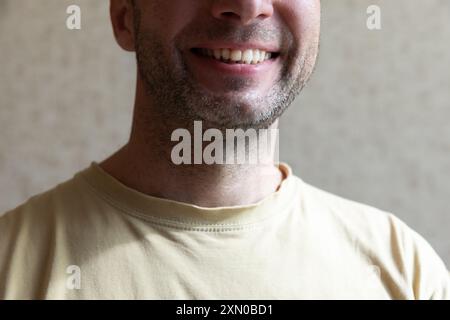 Unrasiertes Kinn und Hals eines lächelnden europäischen Mannes, Nahaufnahme Innenfoto Stockfoto
