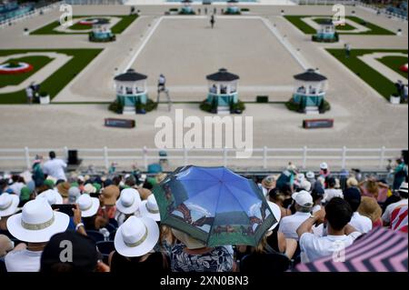 Paris, Fra. 30. Juli 2024. Eine Frau (c) hält einen Regenschirm mit dem Thema „Pferd“ während der Dressurpferdewettkämpfe bei den Olympischen Sommerspielen 2024 in Paris am 30. Juli 2024 in Versailles, Frankreich. (Foto: Anthony Behar/SIPA USA) Credit: SIPA USA/Alamy Live News Stockfoto