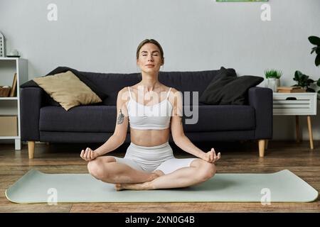 Eine junge Frau mit Vitiligo meditiert in einer friedlichen Wohnung und findet inneren Frieden durch Yoga. Stockfoto