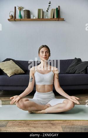 Eine junge Frau mit Vitiligo praktiziert Yoga in einer modernen Wohnung und findet Frieden und innere Kraft durch achtsame Meditation. Stockfoto