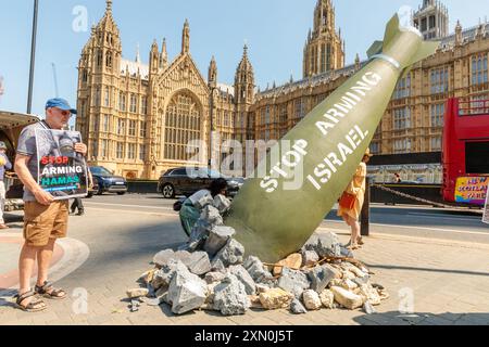 Houses of Parliament, Westminster, London, Großbritannien. 30. Juli 2024. Oxfam protestiert vor den Kammern des Parlaments mit einer Scheinbombe mit der Aufschrift "Stop Arming Israel" als Erklärung gegen Großbritanniens Waffenverkauf an Israel. Quelle: Amanda Rose/Alamy Live News Stockfoto