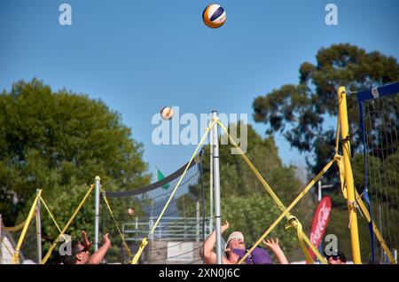 Während des 3x3 Ladeira Beach Volleyball Turniers in Baiona springen die Spieler mit erhobenen Armen und führen einen mächtigen Block in die ne aus Stockfoto