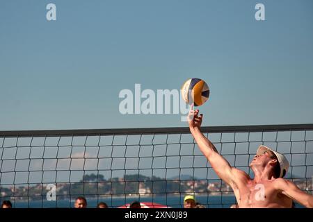 Während des 3x3 Ladeira Beach Volleyball Turniers in Baiona springen die Spieler mit erhobenen Armen und führen einen mächtigen Block in die ne aus Stockfoto