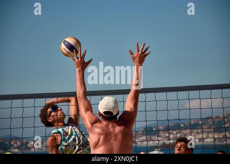 Während des 3x3 Ladeira Beach Volleyball Turniers in Baiona springen die Spieler mit erhobenen Armen und führen einen mächtigen Block in die ne aus Stockfoto