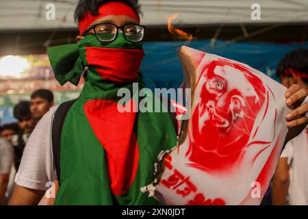 Dhaka, Dhaka, Bangladesch. 30. Juli 2024. Ein Kulturaktivist hält Plakate, die Bangladeschs Premierminister Sheikh Hasina porträtieren und es während des liedmarsches für Opfer, die während der jüngsten landesweiten Studentenproteste über Quoten für Regierungsjobs am 30. Juli 2024 in Dhaka getötet wurden, mit Feuer verbrennen. (Kreditbild: © Abu Sufian Jewel/ZUMA Press Wire) NUR REDAKTIONELLE VERWENDUNG! Nicht für kommerzielle ZWECKE! Stockfoto