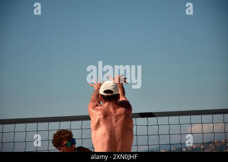 Während des 3x3 Ladeira Beach Volleyball Turniers in Baiona springen die Spieler mit erhobenen Armen und führen einen mächtigen Block in die ne aus Stockfoto
