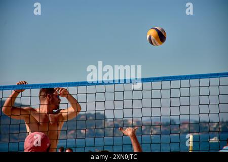 Während des 3x3 Ladeira Beach Volleyball Turniers in Baiona springen die Spieler mit erhobenen Armen und führen einen mächtigen Block in die ne aus Stockfoto