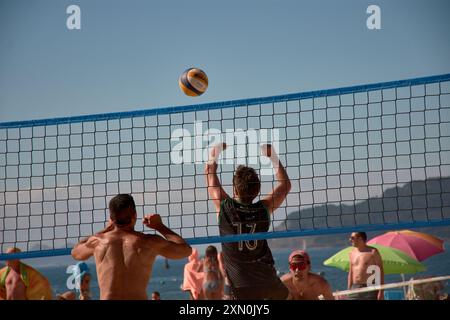 Während des 3x3 Ladeira Beach Volleyball Turniers in Baiona springen die Spieler mit erhobenen Armen und führen einen mächtigen Block in die ne aus Stockfoto