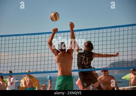 Während des 3x3 Ladeira Beach Volleyball Turniers in Baiona springen die Spieler mit erhobenen Armen und führen einen mächtigen Block in die ne aus Stockfoto