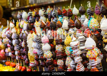 Frischer Erdbeerspieß mit Schokolade am Obststand des berühmten Barcelona Food Market La Boqueria Stockfoto