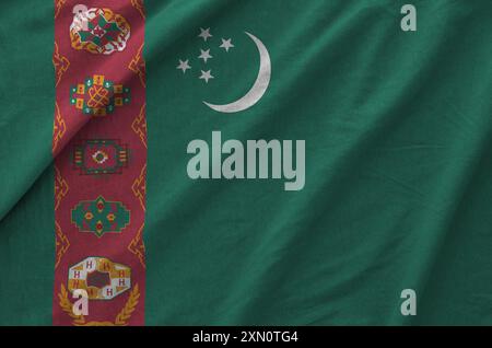 Turkmenistan-Flagge auf gefaltetem, gewelltem Stoff aus altem Tuch in Nahaufnahme dargestellt Stockfoto