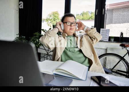 Ein junger Mann mit Down-Syndrom genießt einen Moment der Ruhe mit aufgesetzten Kopfhörern. Stockfoto