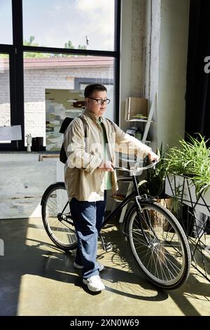 Ein junger Mann mit Down-Syndrom steht neben seinem Fahrrad, bereit zu fahren. Stockfoto