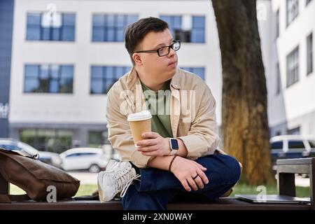 Ein Mann mit Down-Syndrom sitzt auf einer Bank und genießt eine Tasse Kaffee. Stockfoto