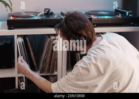 Musikliebhaber wählen Schallplatten mit Plattenspieler Stockfoto