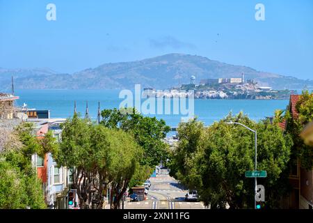 San Francisco, Kalifornien, Vereinigte Staaten von Amerika - 14. Juni 2024: Blick auf die Bucht von San Francisco mit der berühmten Insel Alcatraz im Hintergrund. Bay Street im Vordergrund *** Aussicht auf die Bucht von San Francisco mit der berühmten Insel Alcatraz im Hintergrund. Die Bay Street im Vordergrund Stockfoto