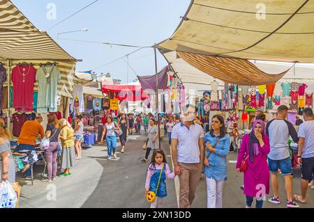 ANTALYA, TÜRKEI - 13. MAI 2017: Die breite, überfüllte Gasse des Cumartesi Basars, gesäumt von Kleiderständen, Bezirk Lara, Antalya, Türkei Stockfoto