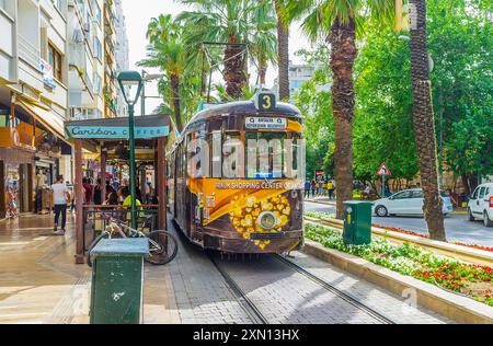 ANTALYA, TÜRKEI - 13. MAI 2017: Die Vintage-Straßenbahn am Bahnhof auf dem grünen, schattigen Touristen Atatürk Boulevard, Barbaros, Antalya, Türkei Stockfoto