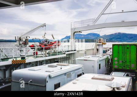 Fahrzeuge auf einer Fähre zu den Lofoten-Inseln, Norwegen. Malerischer Blick auf die Berge im Hintergrund. Perfekt für Reise- und Abenteuerartikel und Blogs. Stockfoto