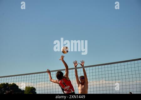 Während des 3x3 Ladeira Beach Volleyball Turniers in Baiona springen die Spieler mit erhobenen Armen und führen einen mächtigen Block in die ne aus Stockfoto