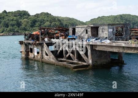 Verlassene Anlegestelle, die als Ablagefläche für alte und stillgelegte Fanggeräte und Trawler-Boome genutzt wurde Stockfoto