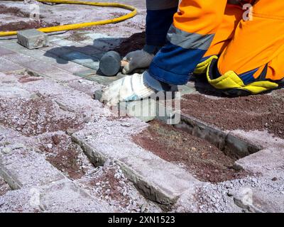 Verlegung neuer Pflasterplatten anstelle beschädigter Stockfoto