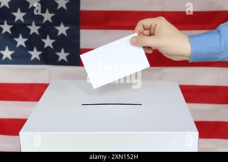 Nahaufnahme einer männlichen Hand, die Stimme in einer Wahlurne mit US-Flagge abgibt Stockfoto