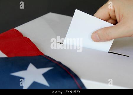 Nahaufnahme einer männlichen Hand, die Stimme in einer Wahlurne mit US-Flagge abgibt Stockfoto