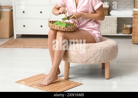 Schöne junge Frau, die Aloe Vera Gel im Badezimmer macht Stockfoto