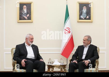 Teheran, Iran. 30. Juli 2024. Der neue iranische Präsident MASOUD PEZESHKIAN (R) trifft in Teheran auf den Hamas-Chef ISMAEIL HANIYEH (L). Porträts an der Wand zeigen den Obersten Führer des Iran, Ayatollah Ali Khamenei (R), und seinen Vorgänger, den späten Gründer der Islamischen Republik, Ayatollah Ruhollah Khomeini. (Credit Image: © Iranian Presidency via ZUMA Press Wire) NUR REDAKTIONELLE VERWENDUNG! Nicht für kommerzielle ZWECKE! Stockfoto