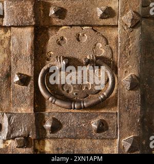 Fragment einer antiken Metalltür mit rundem Griff. Teil einer alten Eisentürnähe. Stockfoto