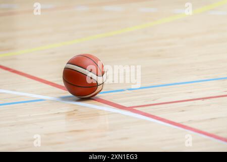 Ein Basketball auf dem Holzboden als Hintergrund. Teamsportkonzept Stockfoto