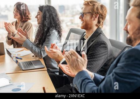 Geschäftsleute applaudieren während eines Meetings in einem modernen Büro Stockfoto
