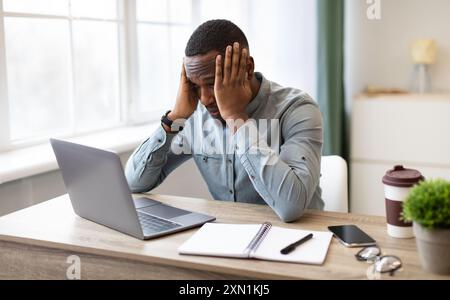 Afrikanischer Geschäftsmann Am Laptop Berühren Kopf Mit Problem Am Arbeitsplatz Stockfoto