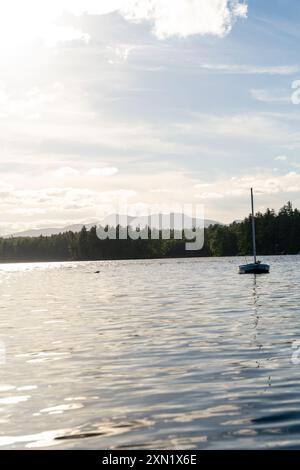 Ein herrlicher Blick auf ein Segelboot auf dem Lake Conway in New Hampshire bei Sonnenuntergang. Stockfoto