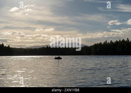 Ein herrlicher Blick auf ein Segelboot auf dem Lake Conway in New Hampshire bei Sonnenuntergang. Stockfoto