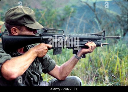 Ein US-amerikanischer Soldat feuert seinen XM16E1 mit einem XM148-Granatwerfer während einer Mission in der Provinz Quang Ngai, Republik Vietnam Stockfoto