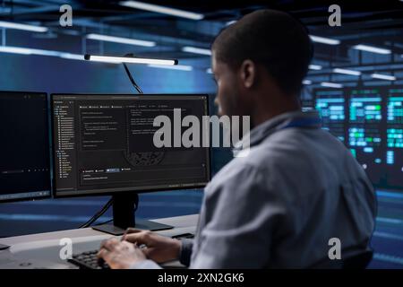 Softwareentwickler konfigurieren die Serverfarm neu, um sie für die Datenverarbeitungsanforderungen der Kunden zu optimieren. afroamerikanischer Mann, der sicherstellt, dass die Rechenzentrumsausrüstung effizient funktioniert Stockfoto