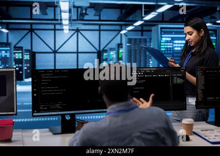 Ingenieur in der Serverfarm, der den Wiederherstellungsplan überprüft und den Energieverbrauch des Rechenzentrums überwacht. Mitarbeiter im Serverraum stellen sicher, dass die Sensoren optimal funktionieren, und führen routinemäßige Datenträgerprüfungen durch Stockfoto