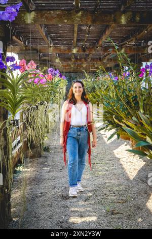 Brasilianische Frau posiert zwischen den Blumen. Im Botanischen Garten Jardim in São Paulo, Brasilien. Stockfoto