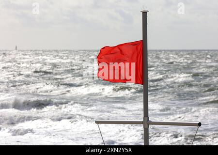 Rote Flagge am Strand von Westerland, Sylt DEU, Deutschland, Sylt, Westerland: Das Bild zeigt eine rote Flagge, die im Wind weht, auf einem Rettungsturm am Strand von Westerland auf Sylt. Die rote Flagge weist auf ein Badeverbot und Lebensgefahr beim Baden hin. Im Hintergrund ist die stürmische Nordsee zu sehen. Westerland Sylt Schleswig Holstein Deutschland *** Rote Flagge am Strand von Westerland, Sylt DEU, Deutschland, Sylt, Westerland das Bild zeigt eine im Wind winkende rote Flagge auf einem Rettungsturm am Strand von Westerland auf Sylt die rote Flagge weist auf ein Badeverbot und Lebensgefahr hin Stockfoto