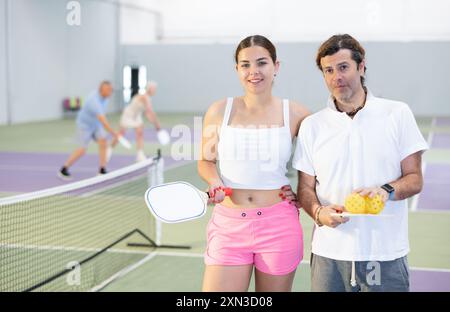 Junge Mädchen und Erwachsene, Pickleball-Spieler, die auf dem Platz stehen Stockfoto