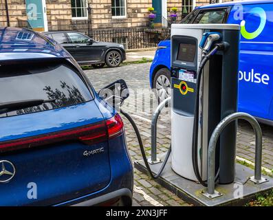 Edinburgh, Schottland, 07.17.2024: Blaues Elektroauto lädt seine Batterien an einer Straßenladestelle in Edinburgh auf Stockfoto