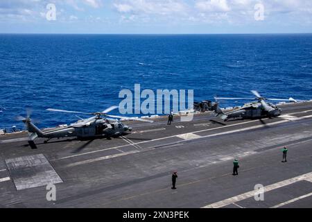 Zwei MH-60S Seahawks, die den „Black Knights“ der Helicopter Sea Combat Squadron (HSC) 4 zugeordnet sind, bereiten sich auf den Start vom Flugdeck des Flugzeugträgers USS Carl Vinson (CVN 70) der Nimitz-Klasse während der Übung Rim of Pacific (RIMPAC) 2024 vor. 29 Nationen, 40 Überlandschiffe, drei U-Boote, 14 nationale Landstreitkräfte, mehr als 150 Flugzeuge und 25.000 Mitarbeiter nehmen vom 27. Juni bis 1. August an der RIMPAC Teil. RIMPAC, die weltweit größte internationale maritime Übung, bietet eine einzigartige Ausbildungsmöglichkeit und fördert und pflegt gleichzeitig kooperative Beziehungen Stockfoto