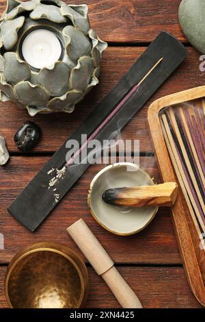 Flache Lagenkomposition mit Räucherstäbchen auf Holztisch. OM-Ligatur Stockfoto