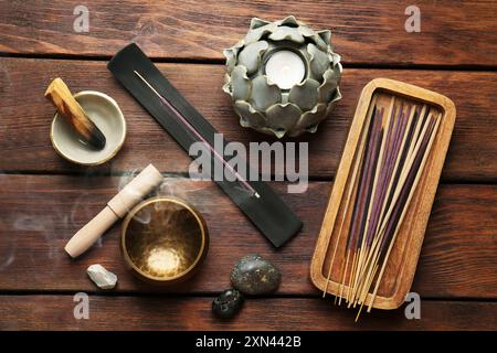 Flache Lagenkomposition mit Räucherstäbchen auf Holztisch. OM-Ligatur Stockfoto